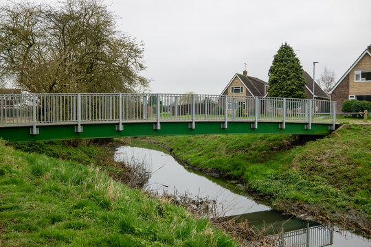 A metal footbridge over Werrington Brook, Cuckoos Hollow, Peterborough on a dull day