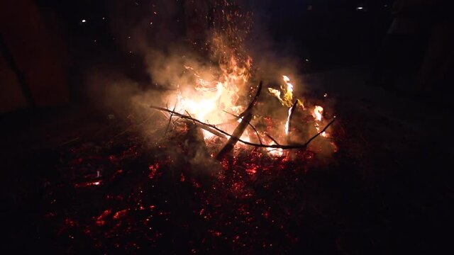 Image of a pile of trash burning in slow motion during the night.