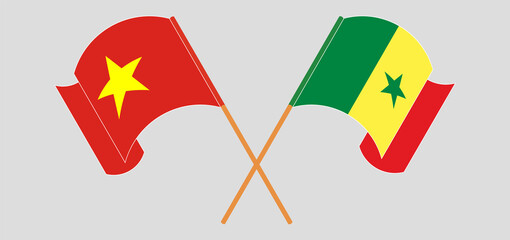 Crossed and waving flags of Vietnam and Senegal