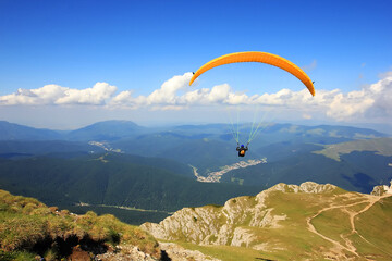 Paraglider prepareing to take off from a mountain - obrazy, fototapety, plakaty