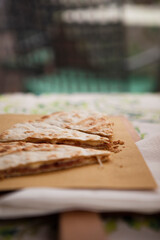 Italian traditional street food. Piadina or Piada is a thin Italian flatbread with cheese, ham, rocket, arugula, tomatoes in the northern Italy, Lombardy region, Milan. European cuisine.