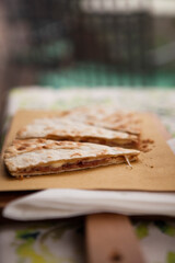 Italian traditional street food. Piadina or Piada is a thin Italian flatbread with cheese, ham, rocket, arugula, tomatoes in the northern Italy, Lombardy region, Milan. European cuisine.