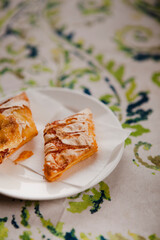Italian food. Traditional sweet pastry made of sugar dough with jam filling in northern Italy in Salo, Lombardy region. Two pieces of cookies on a white plate on a table with a colorful tablecloth.