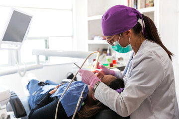 Dentist with glasses and mask during the patient's treatment in a dental office