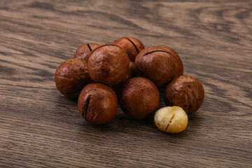 Brown macadamia nut heap over background
