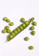 A pod of green peas with salty seeds. Green peas on a white background.