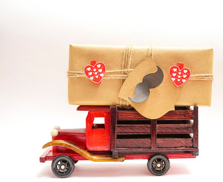 Father's Day greeting message with wooden toy truck with gift box in the back on white red paper background. Happy fathers day concept. - Powered by Adobe