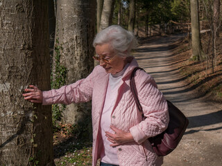 Senior woman has pain while walking in the park  - 425123929