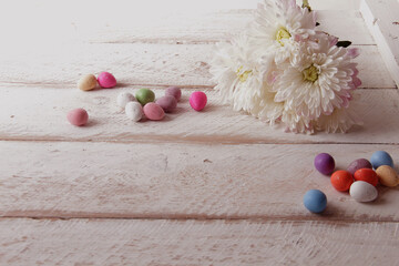 White chrysanthemums on a white background. Delicate Easter background. Flowers and Easter Eggs