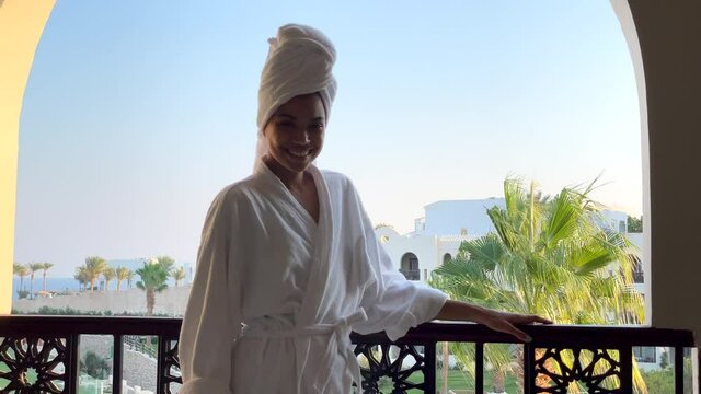 Experience relax. Young woman turns around and smiles at camera that moves towards her. Luxury resort, relax, spa concept
