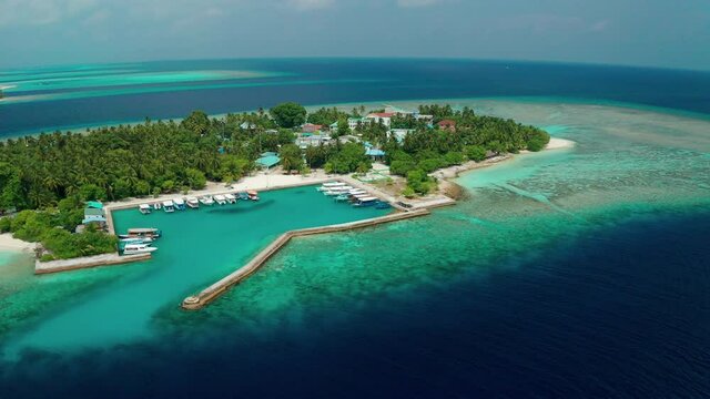 Drone view of a tropical island with a hotel and residential property. Thinadhoo (Vaavu Atoll), Maldives