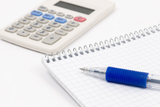 Pen on the notes with calculator in the background. Finance and economy concept.