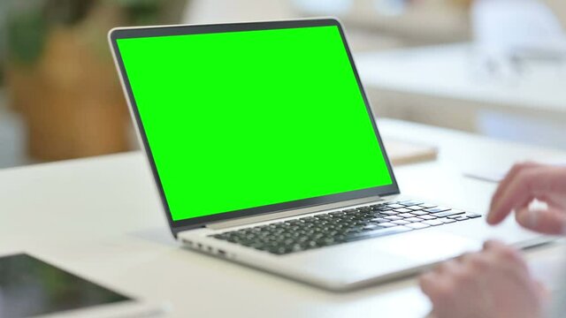 Rear View of Young Man using Laptop with Chroma Screen 