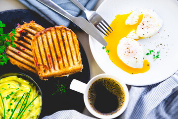 Morning poached eggs with a roasted sandwich and a cup of coffee