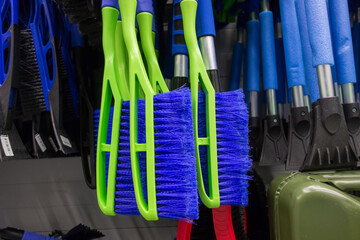 brushes and scrapers for cleaning car snow hang in the supermarket