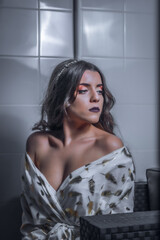 Mujer con vestido blanco y dorado en estudio.