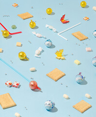 Creative pattern made with colorful candies, chocolate and cookies on pastel blue background. Minimal party concept.