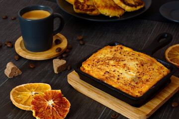Curd casserole and a cup of coffee on a black table. Breakfast serving. - 425147563