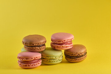 Cake macaron close up on yellow background flavor almond cookies pastel colors.