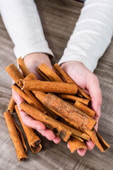 Close-up Of Human Hand Holding Cinnamon Sticks.