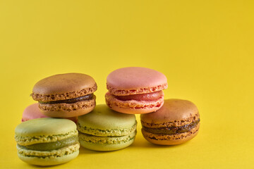 Cake macaron close up on yellow background flavor almond cookies pastel colors.