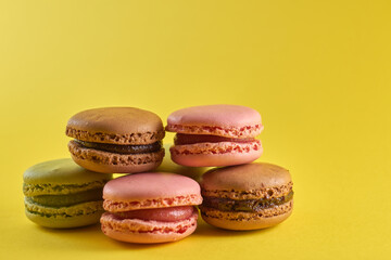 Obraz na płótnie Canvas Cake macaron close up on yellow background flavor almond cookies pastel colors.