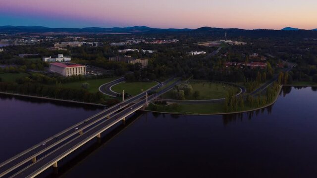 Aerial hyperlapse of Commonwealth Bridge on Lake Burley Griffin at dusk in Canberra, the capital of Australia 