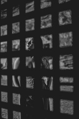 Mujer entre rejas antiguas de metal