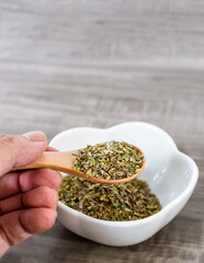 Close up of wooden spoon with oregano.