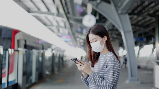 Young asian woman cover mouth , wear medical face mask to protect viruses.standing distance of 1 meter from other people keep distance protect from COVID-19 viruses.social distance.