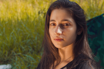 Brunette woman camping with yellowish grass background