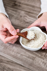 Close up of wooden spoon with rice grains.