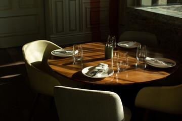 Wooden table near the window in the restaurant. Beautiful sunny light
