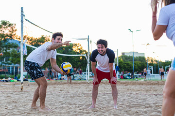 three friends playing beach volleyball, enjoying the summer, friends giving tips strategy to win...