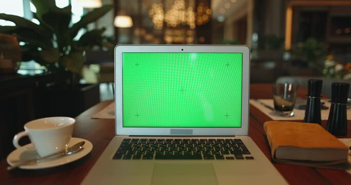 Close up shot of laptop green chroma key screen. Computer with mock up display set for work in office cafeteria - technology, business and office 4k footage