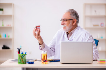 Old male dentist working in the clinic