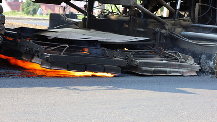 Fire burned the road with a machine. The heater is burning the surface on the old paved road to...