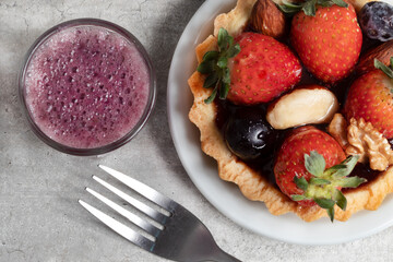 Top view of fruits and berry tartlet dessert and grape juice.