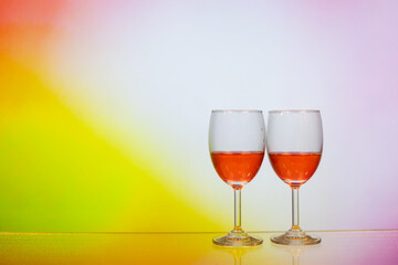 two glasses of red wine, with colourful rosy background. Concept of romantic mother father valentine wedding day