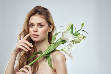Naklejka premium girl with flowers cropped view portrait close-up spring bare shoulders clear skin Make Up
