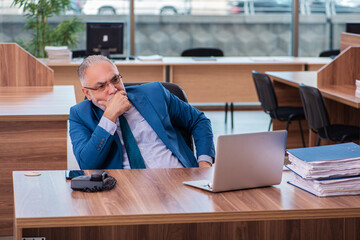 Old male employee working in the office