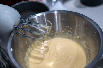 child baking in the kitchen, using electric beater making a cake
