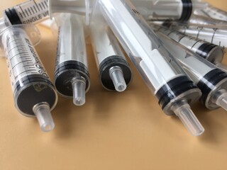used medical syringes without needles on a beige background