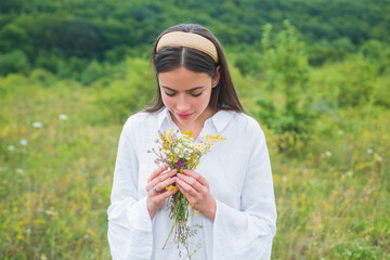 Organic field. Spring girl in field. Healthy lifestyle. Woman in meadow with wildflowers.