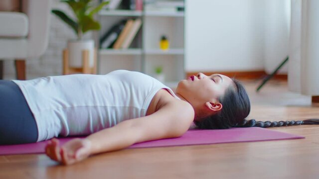 Calm of Asian woman practice yoga Dead Body or Savasana pose with meditation smile at home Feeling so comfortable and relax,Healthcare Concept
