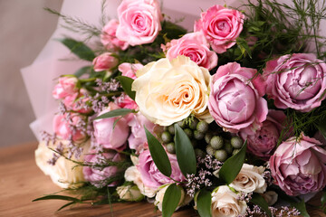 Beautiful bouquet with roses on wooden table, closeup