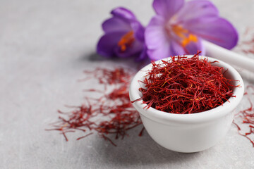 Dried saffron and crocus flowers on grey table, closeup. Space for text