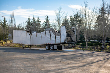 Burned damaged dry van semi trailer without semi truck standing on the industrial parking lot waiting for repair