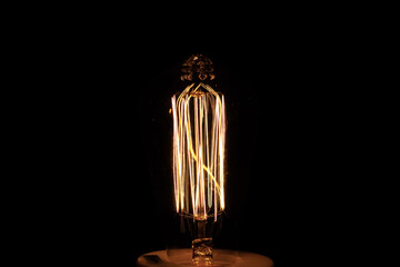 Closeup of light bulb against on black background.