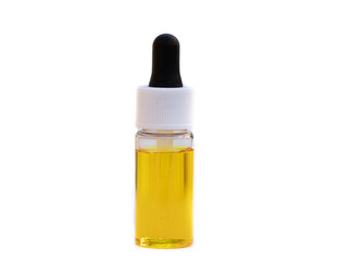 Yellow oil in a clear glass oil dropper bottle isolated on a white background.